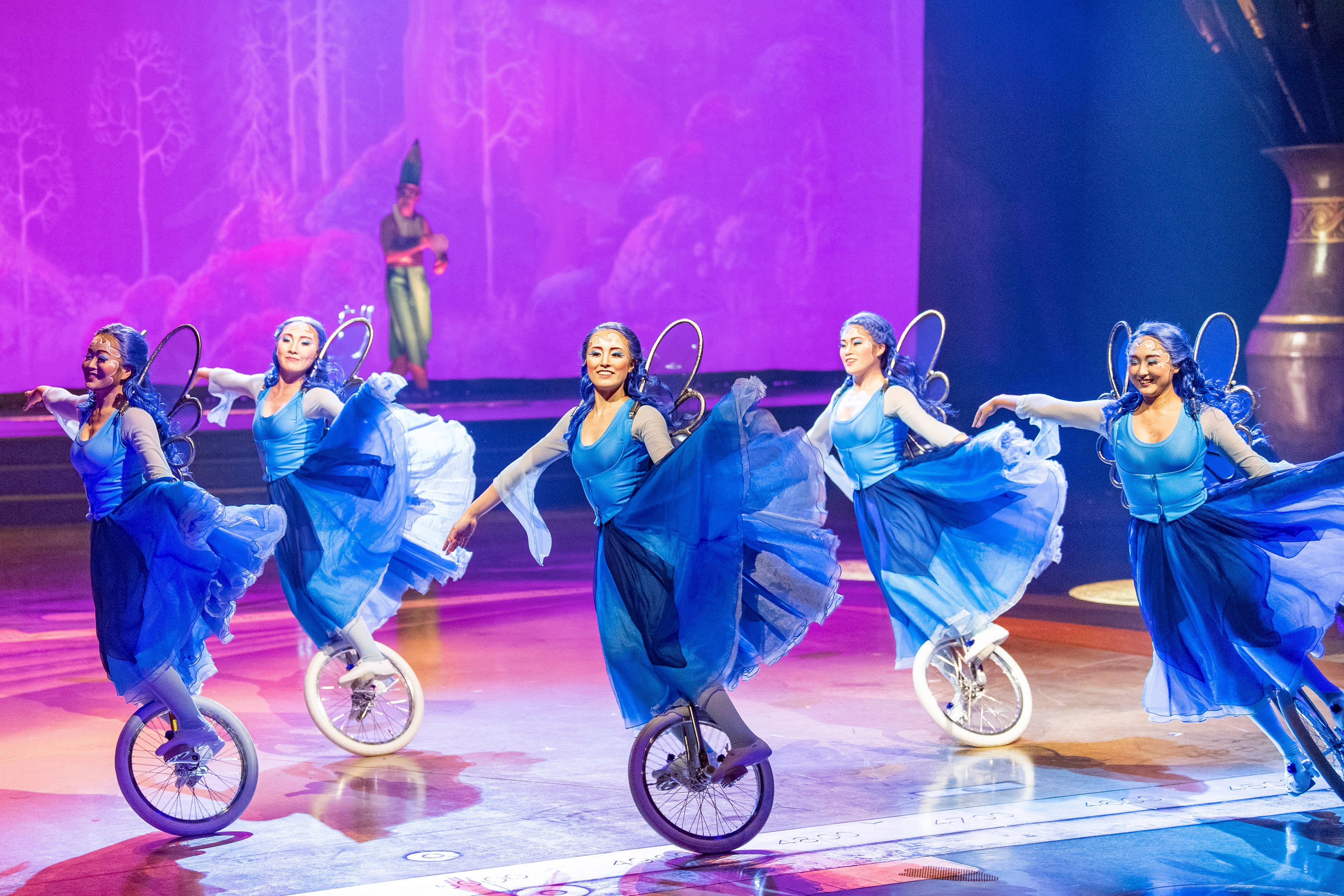 Five playful unicyclists representing the Blue Fairy from the classic Disney Animation film “Pinocchio” appear to effortlessly float across the stage during Drawn to Life