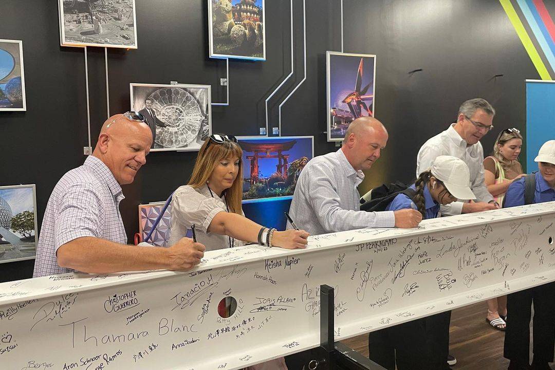 Walt Disney World Cast Members sign a steel beam that will be part of the new World Celebration at EPCOT