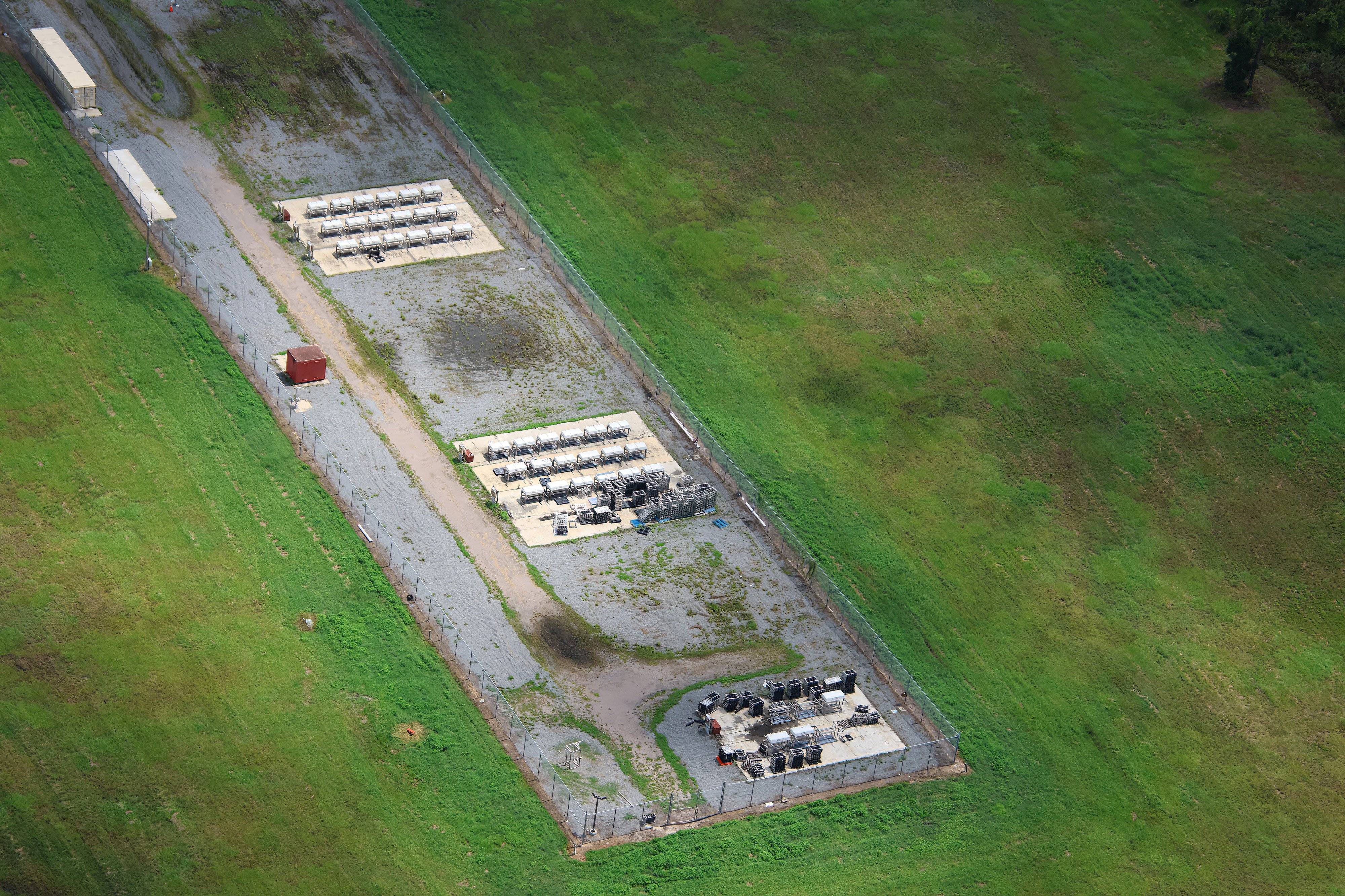 Aerial view of the fenced World Drive fireworks launch site showing three equipment pads