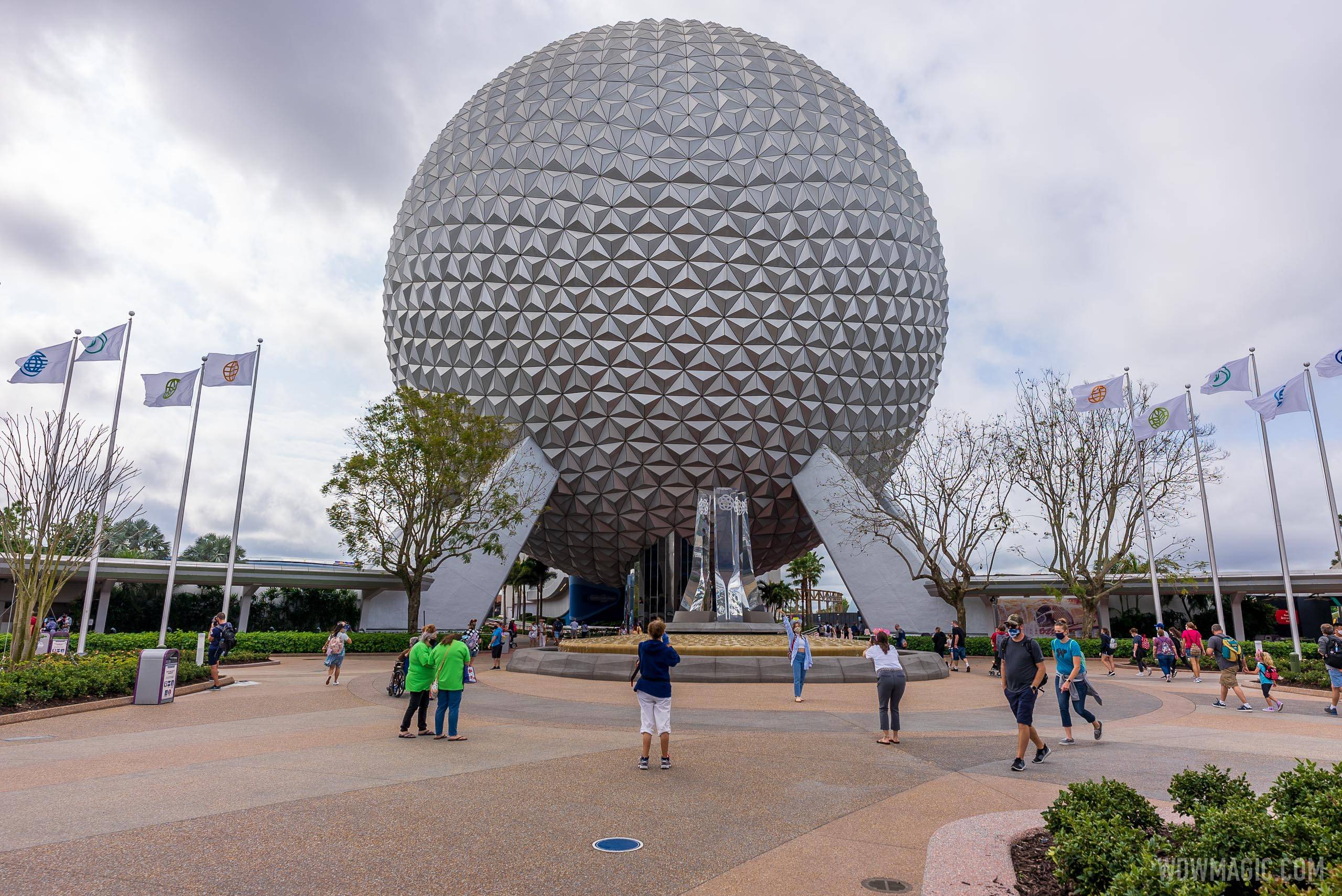Guests posing for photo in-front of Spaceship Earth