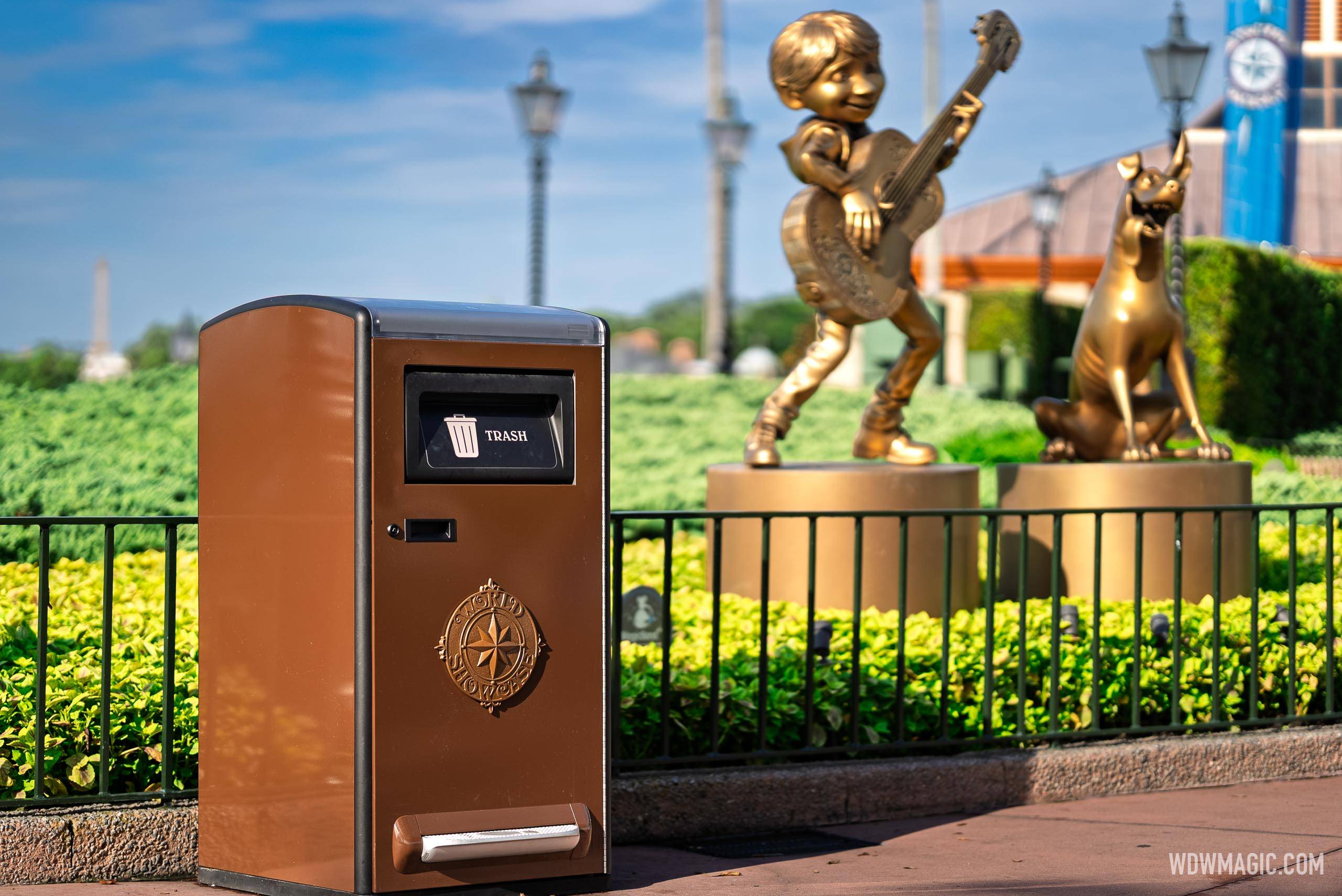 New World Showcase-medallion Bigbelly Smart Max trash bin near the Miguel and Dante statues at EPCOT's World Showcase entrance