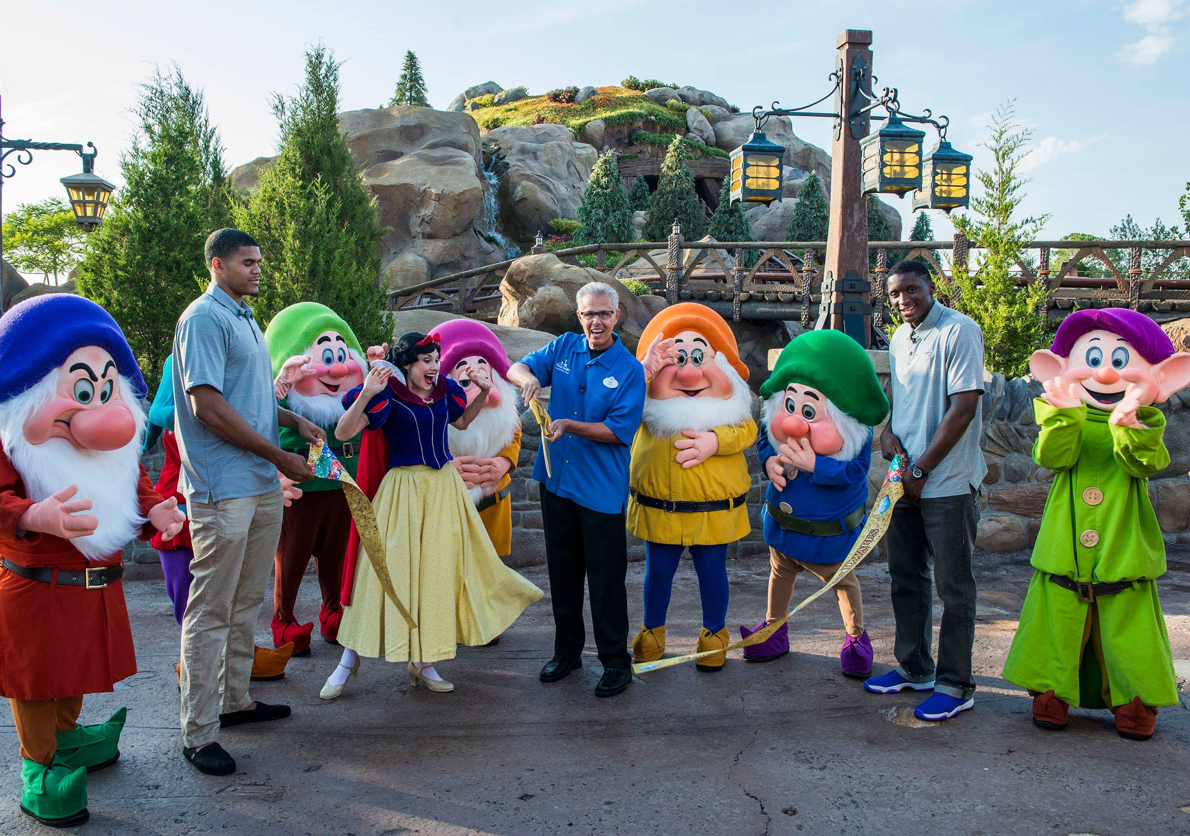 Snow White and the Seven Dwarfs join Phil Holmes (center), vice president of Magic Kingdom Park, and Orlando Magic players Tobias Harris (left) and Victor Oladipo (right)