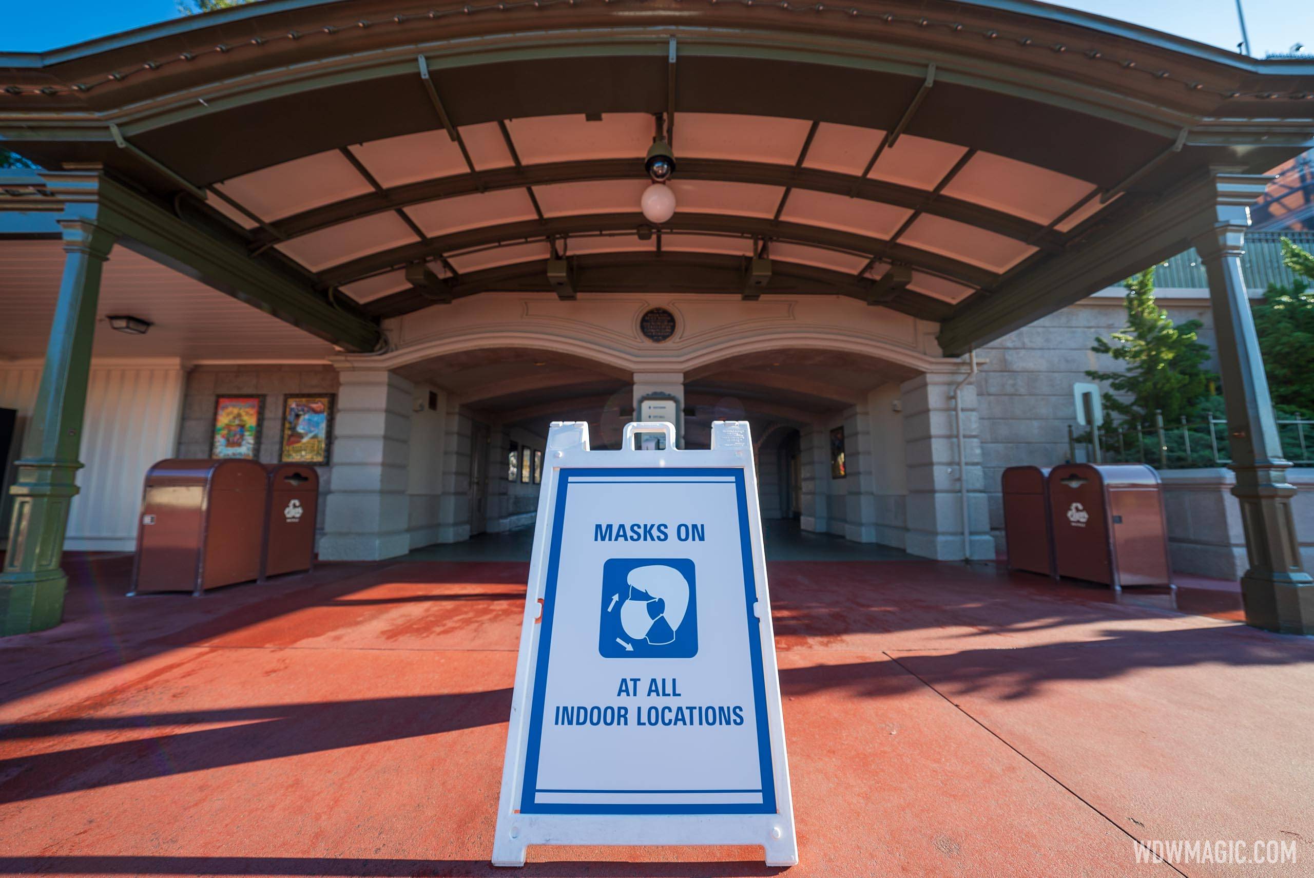 Signs at the front of Magic Kingdom remind guests that masks are currently required indoors