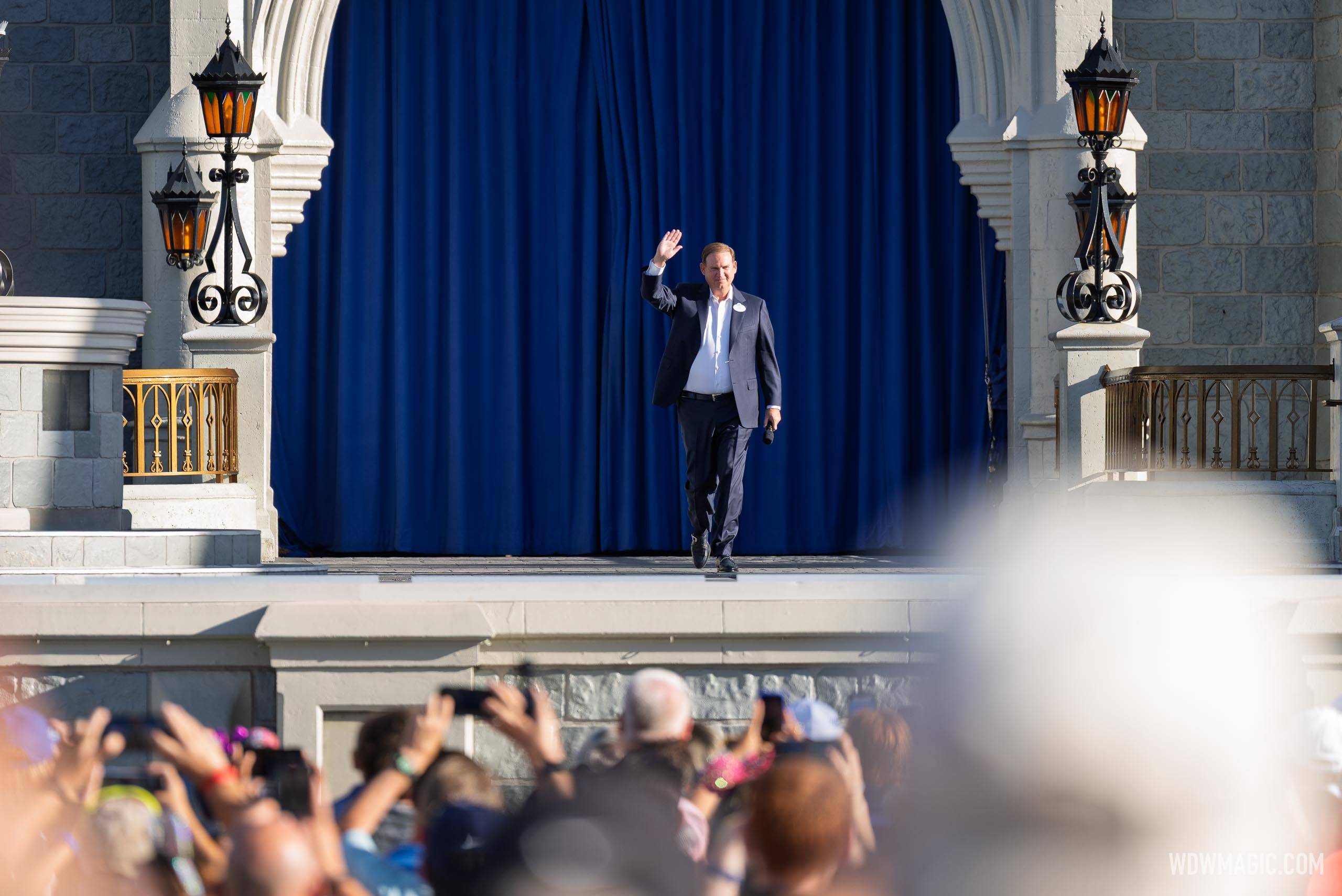 Joe Schott waves to the crowd from the Cinderella Castle stage during the Walt Disney World 55th anniversary celebration