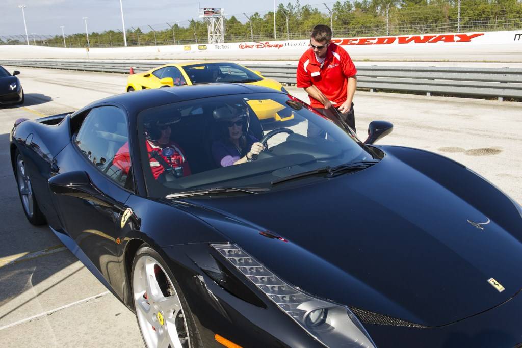 Pit crew loading a guest into the Ferrari