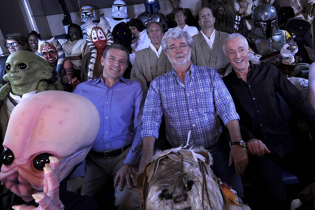 Walt Disney Co. president and CEO Bob Iger (left) "Star Wars" creator George Lucas (center) and actor Anthony Daniels, who portrayed C-3PO in "Star Wars" (right), pose with "Star Wars" characters May 20, 2011 inside a "Star Tours" ride vehicle at Disney's Hollywood Studios