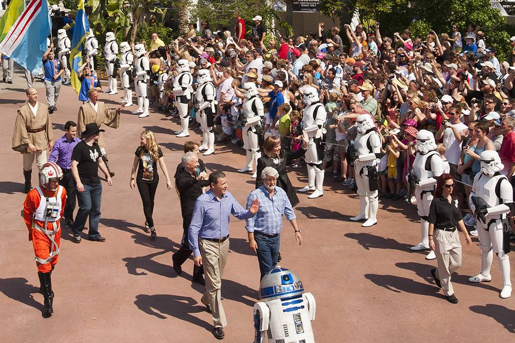Walt Disney Co. president and CEO Bob Iger (left) waves as he walks with "Star Wars" creator George Lucas through Disney's Hollywood Studios theme park 