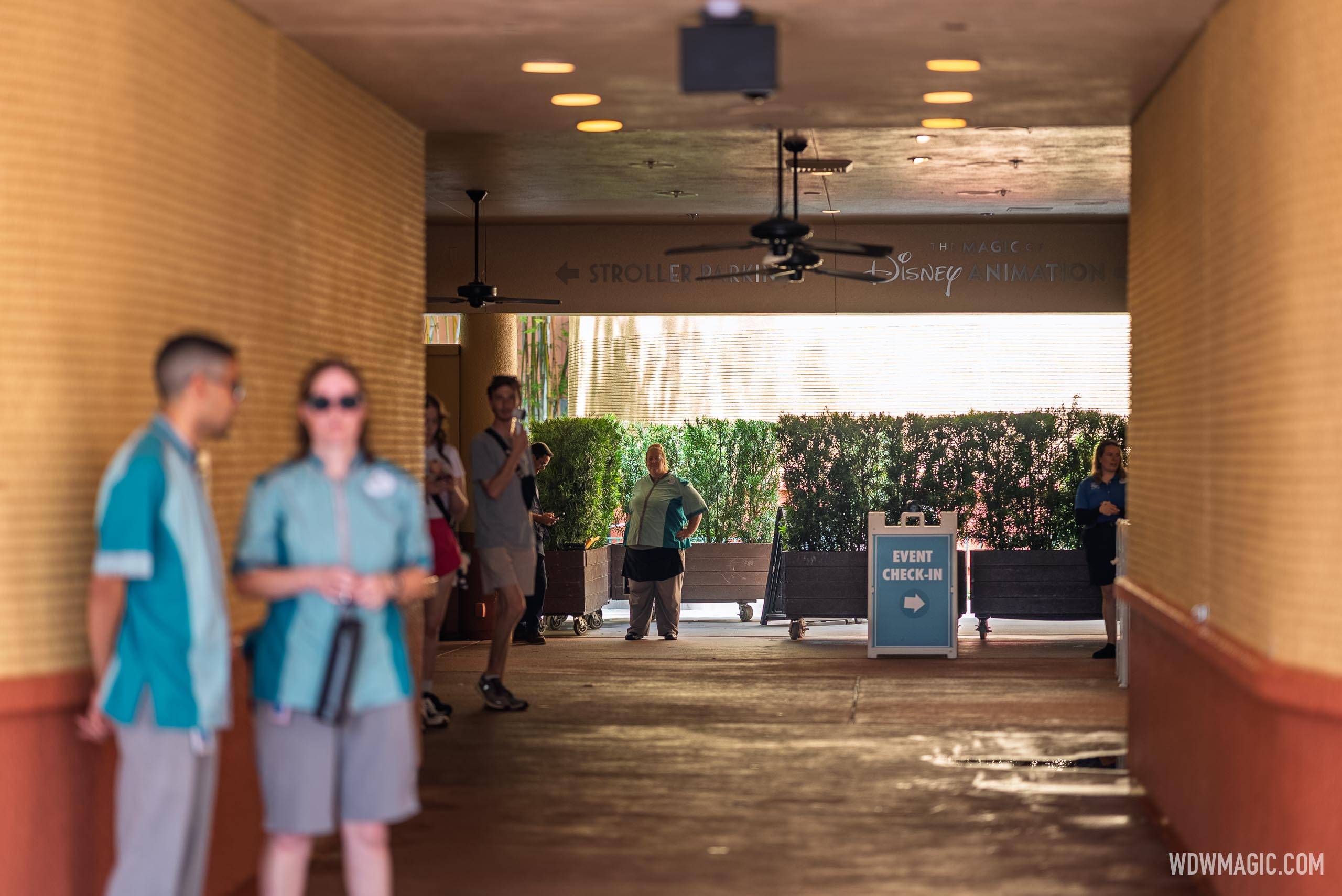 Cast Members gather near the Event Check-In sign at the entrance corridor of The Magic of Disney Animation during the cast preview