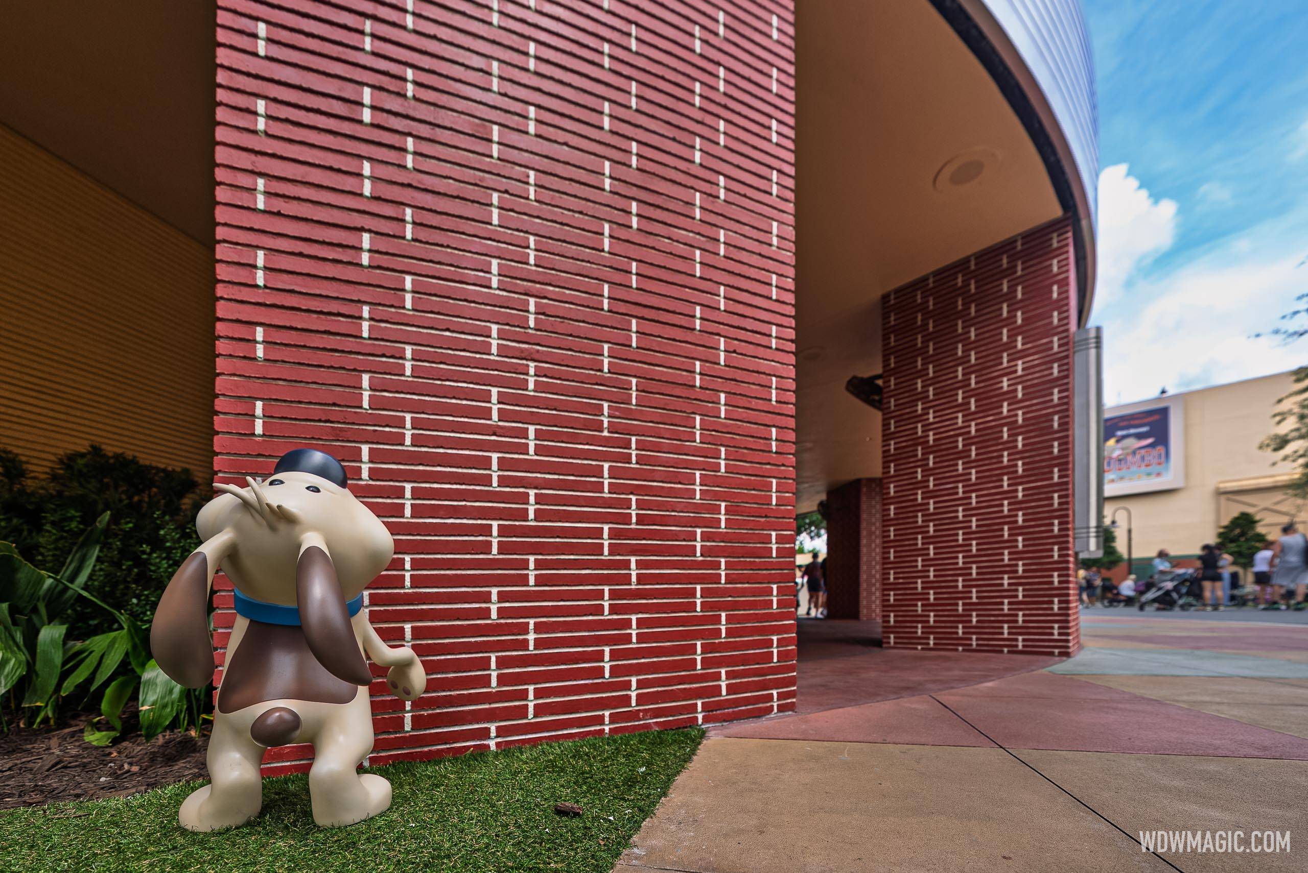Little Brother from Mulan stands beside the brick wall outside The Magic of Disney Animation