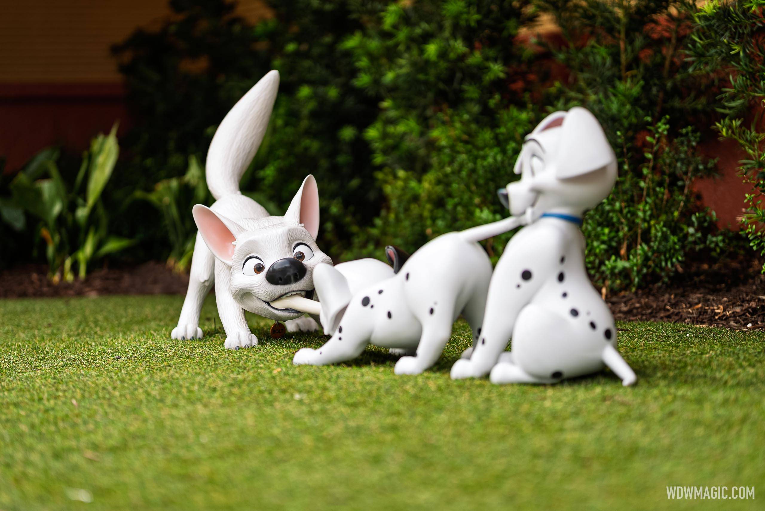 Bolt leans playfully toward two dalmatian puppies in the courtyard outside The Magic of Disney Animation