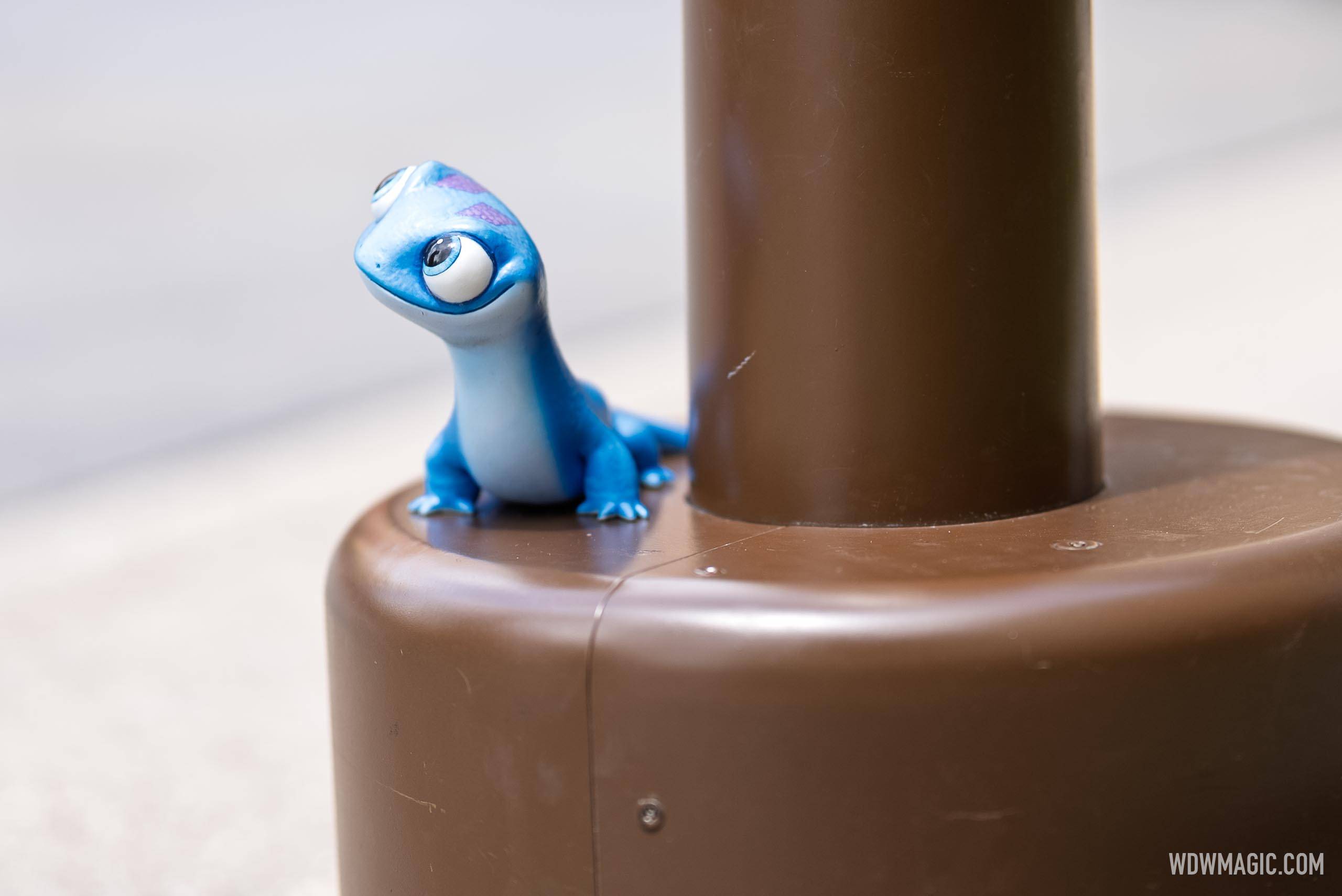Bruni from Frozen 2 sits at the base of a lamppost in the Walt Disney Studios courtyard outside The Magic of Disney Animation