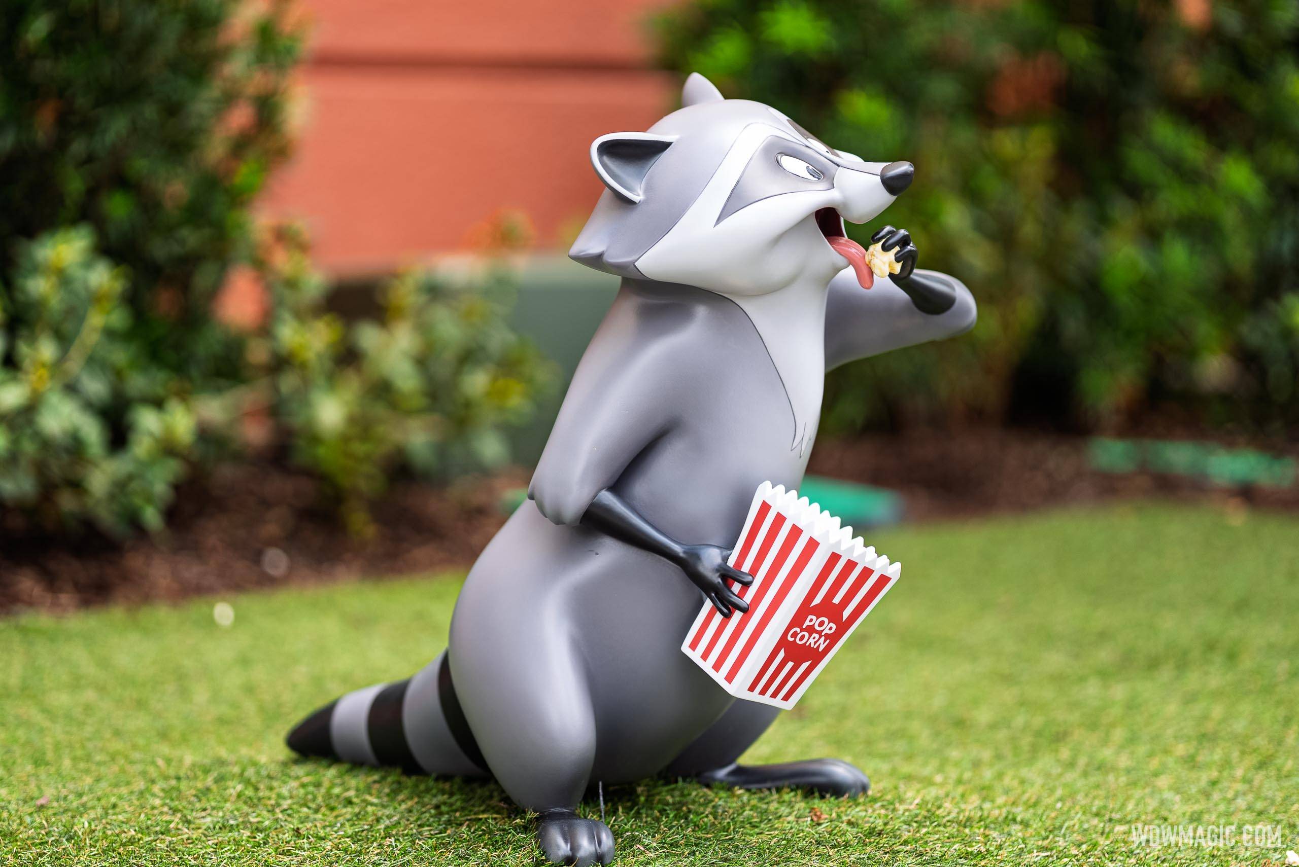 Meeko from Pocahontas clutches a popcorn bucket while snacking in the Walt Disney Studios courtyard outside The Magic of Disney Animation