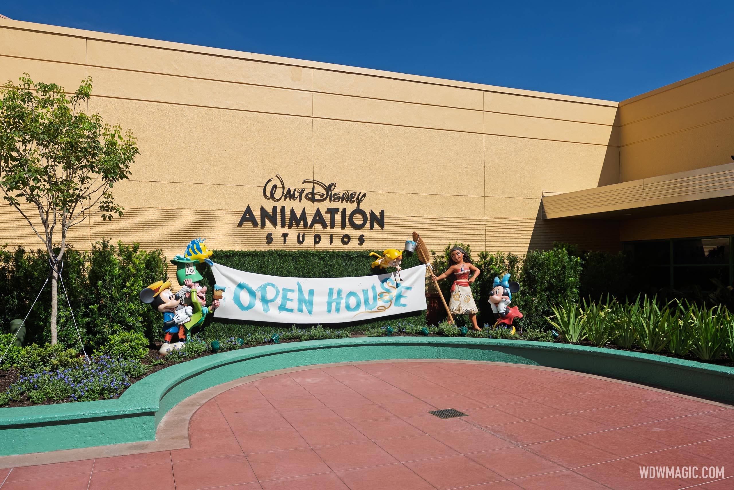 An "Open House" banner held by character statues including Mickey, Goofy, Tinker Bell, Moana, and Minnie Mouse stands in the Walt Disney Animation Studios courtyard