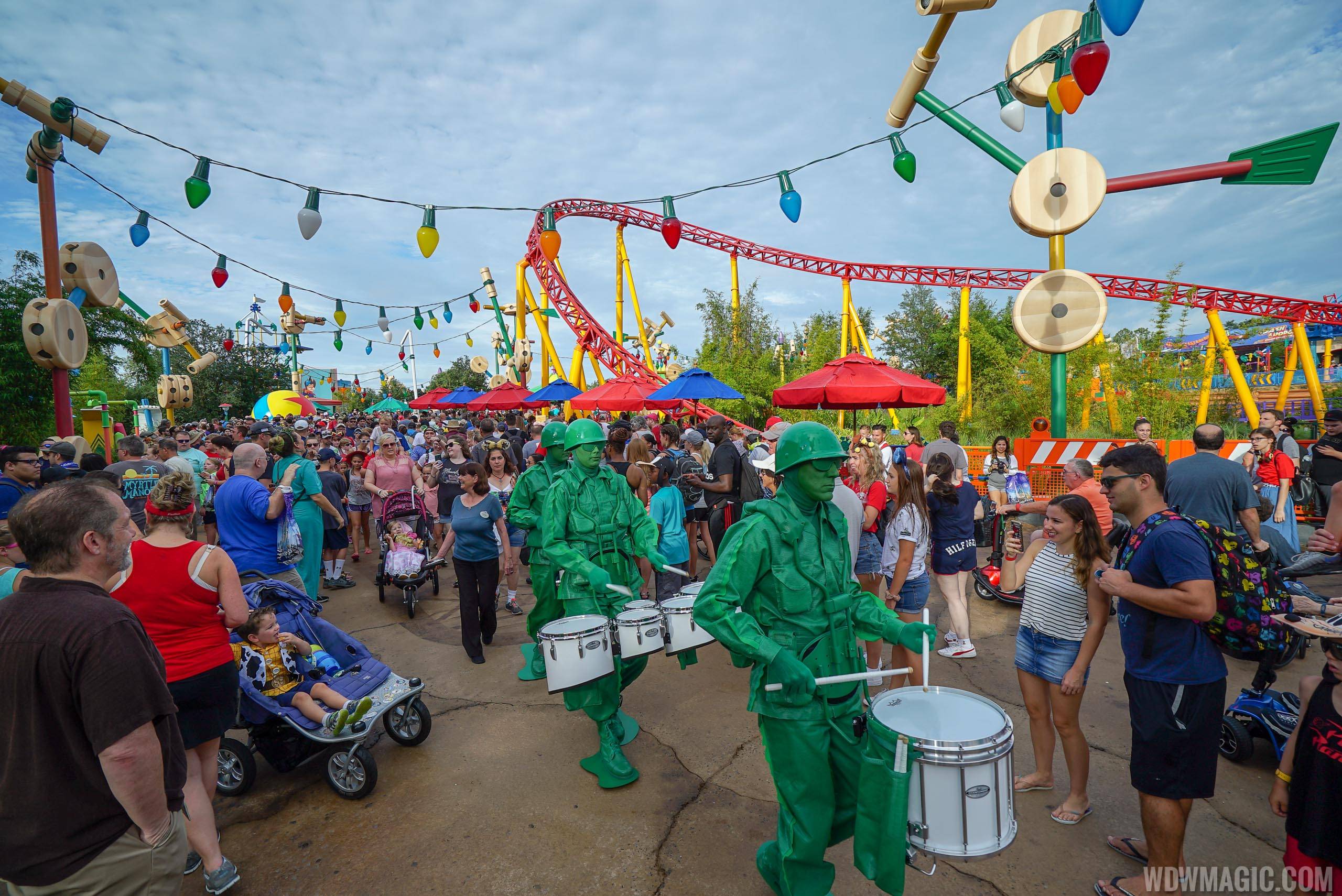Green Army Drum Corps make their way through a busy Toy Story Land