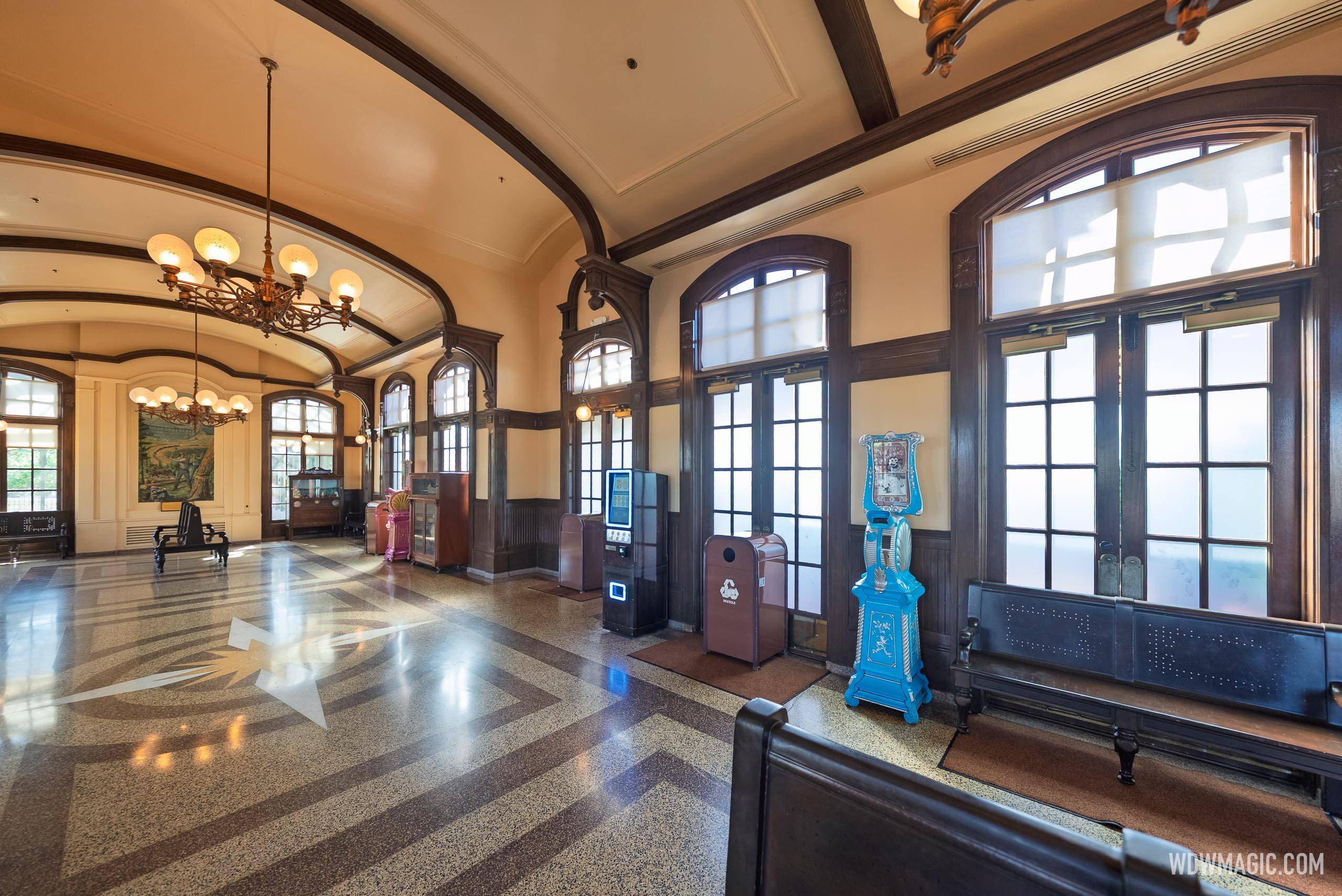 The waiting area inside the Main Street, U.S.A. train station, featuring vintage-style penny arcade machines and benches