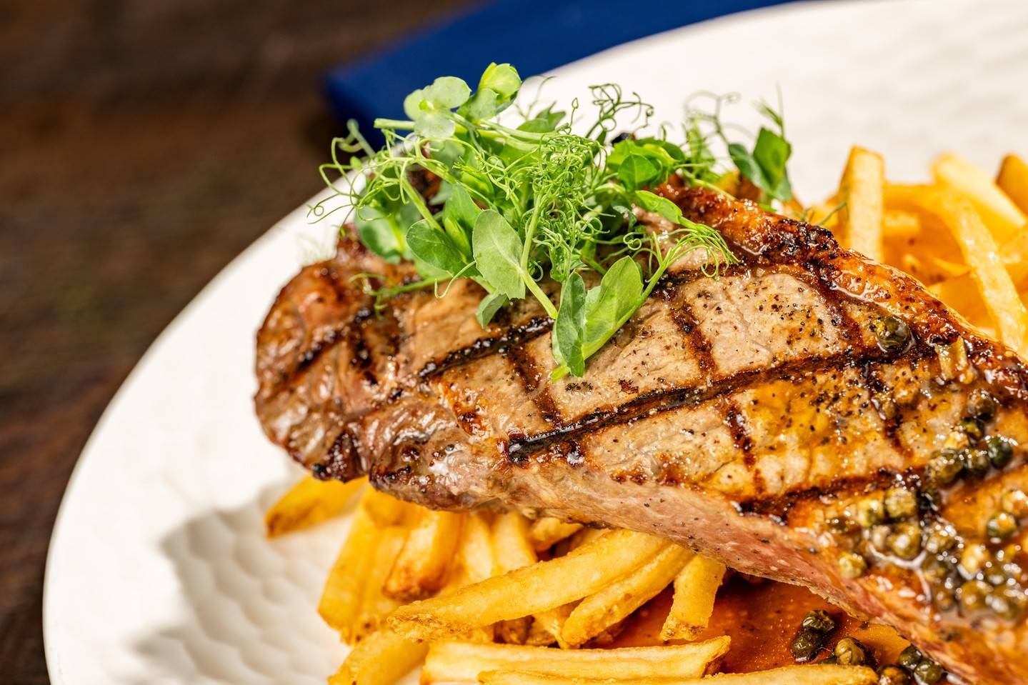 Steak Frites: Grilled 12-oz New York steak, shoestring fries, au poivre sauce (available lunch)