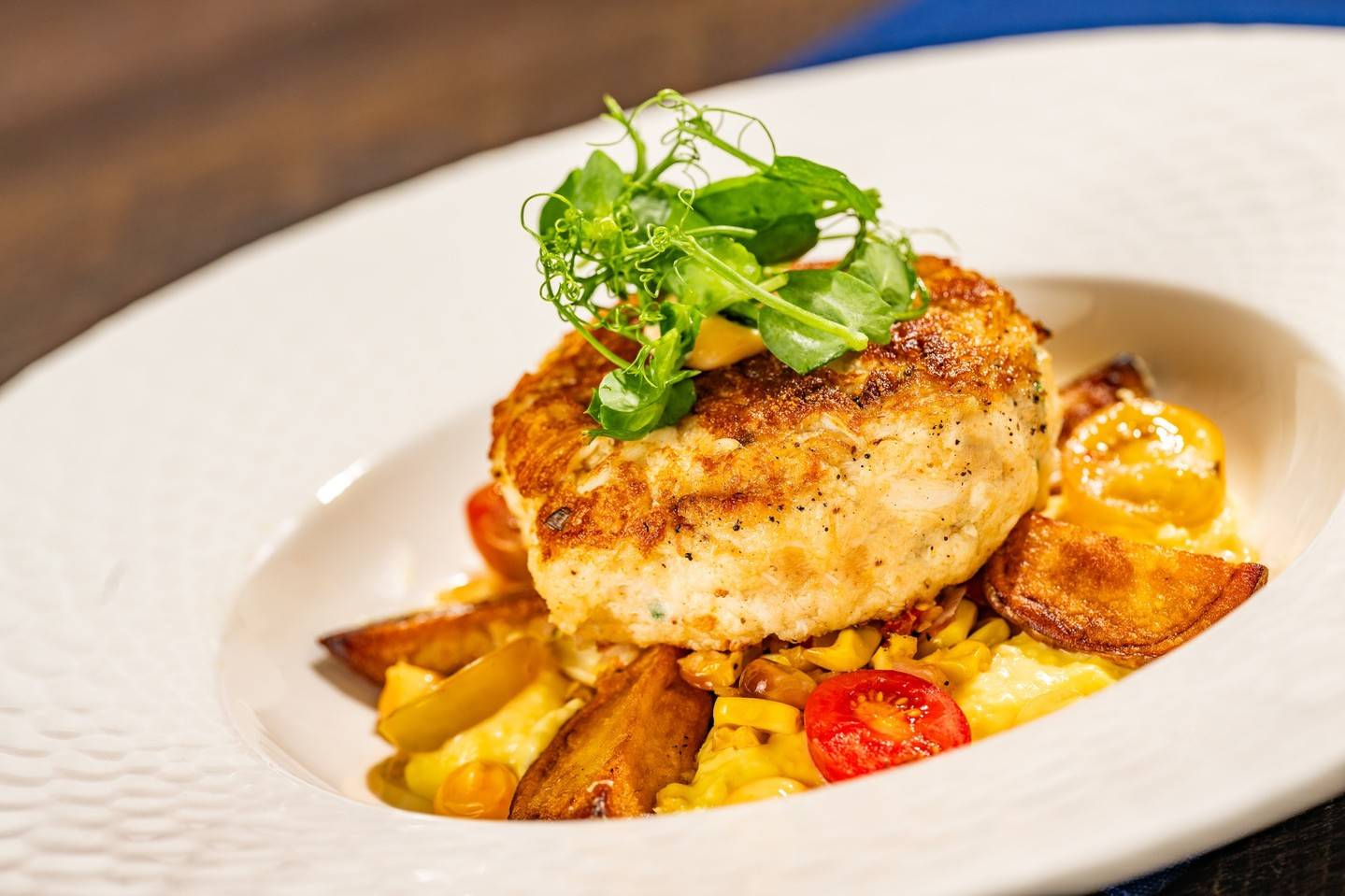 Maryland-style Crab Cake: Corn pur&eacute;e, tomato succotash, roasted baby red potatoes, spicy a&iuml;oli (available lunch and dinner)
