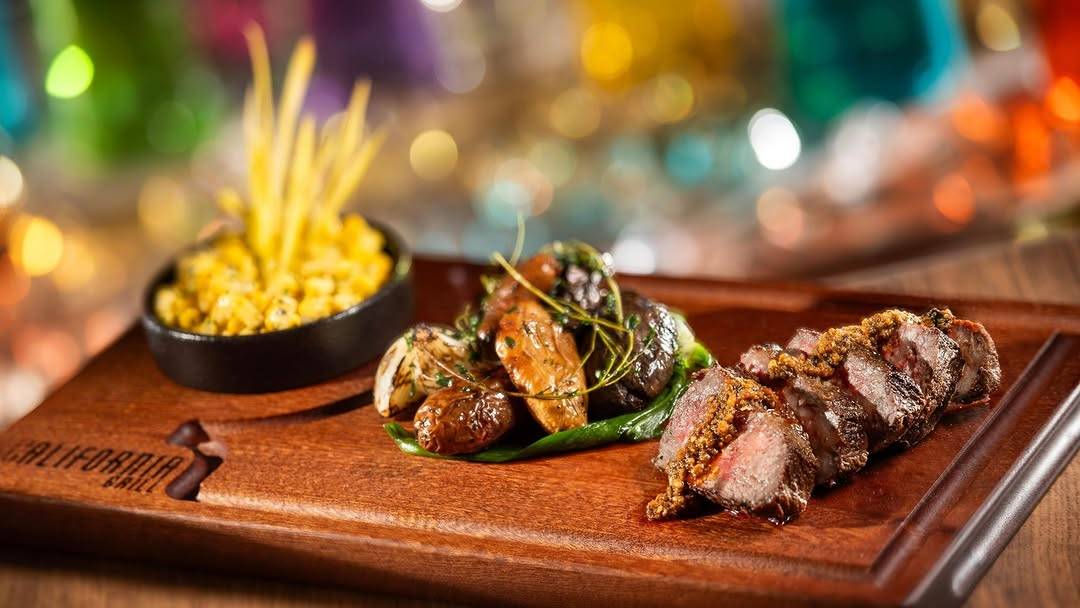 Wagyu Strip Loin: Corn, beef tallow-herb fingerling potatoes, grilled green garlic, and salsa macha