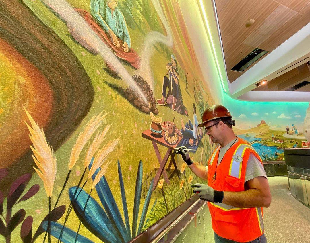 Working on the hand-painted 160 feet long mural at Connections Eatery
