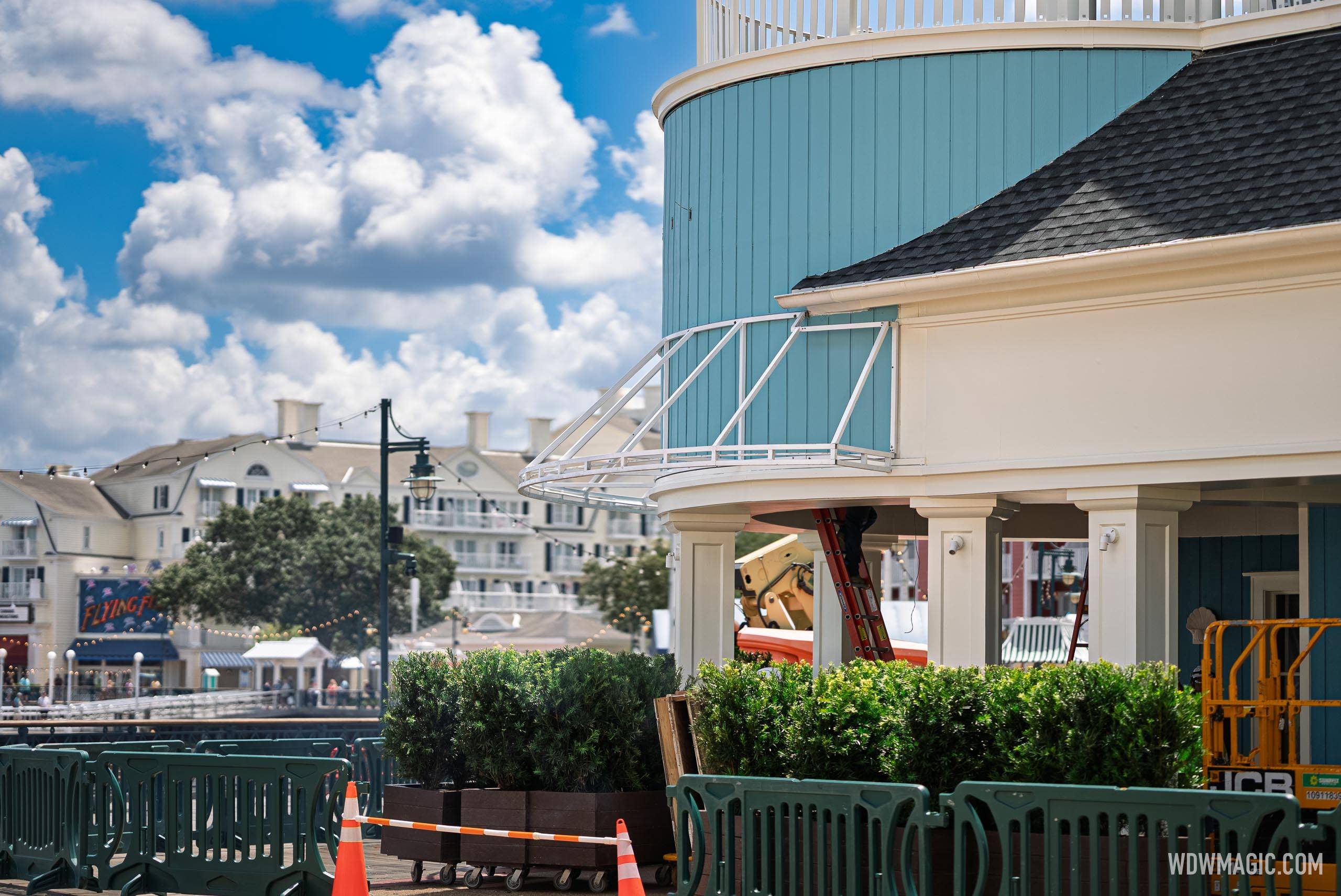 The curved upper balcony railing and teal facade of Hurly-Burly are visible with construction equipment staged below, as Flying Fish and the BoardWalk resort hotels appear in the background