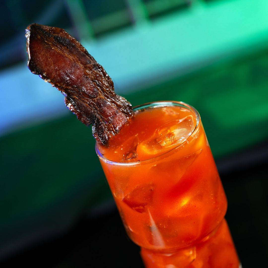 Bloody Rancor with Candied Meat: Tito's Handmade Vodka, Ancho Reyes Chile Liqueur, and house-made bloody mary mix garnished with a spicy candied rancor bacon