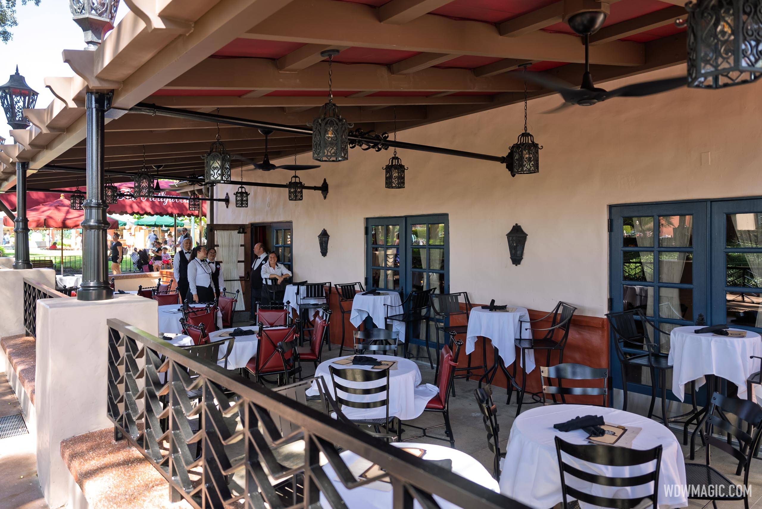 The refurbished Hollywood Brown Derby Lounge patio features a new permanent overhead canopy, updated pendant lighting, ceiling fans, and red and black seating with white-clothed tables
