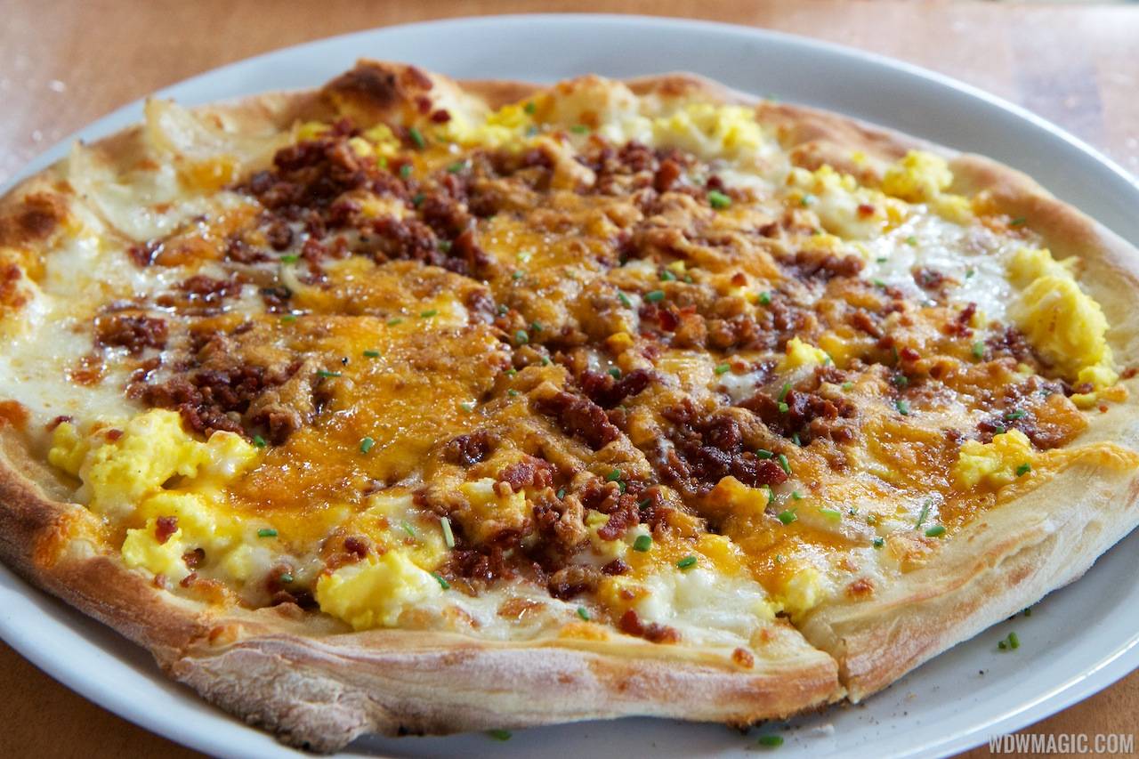 Wolfgang Puck Express Marketplace breakfast - Breakfast Pizza, scrambled eggs, bacon, tomatoes, mozzarella, cheddar, caramelized onions $11