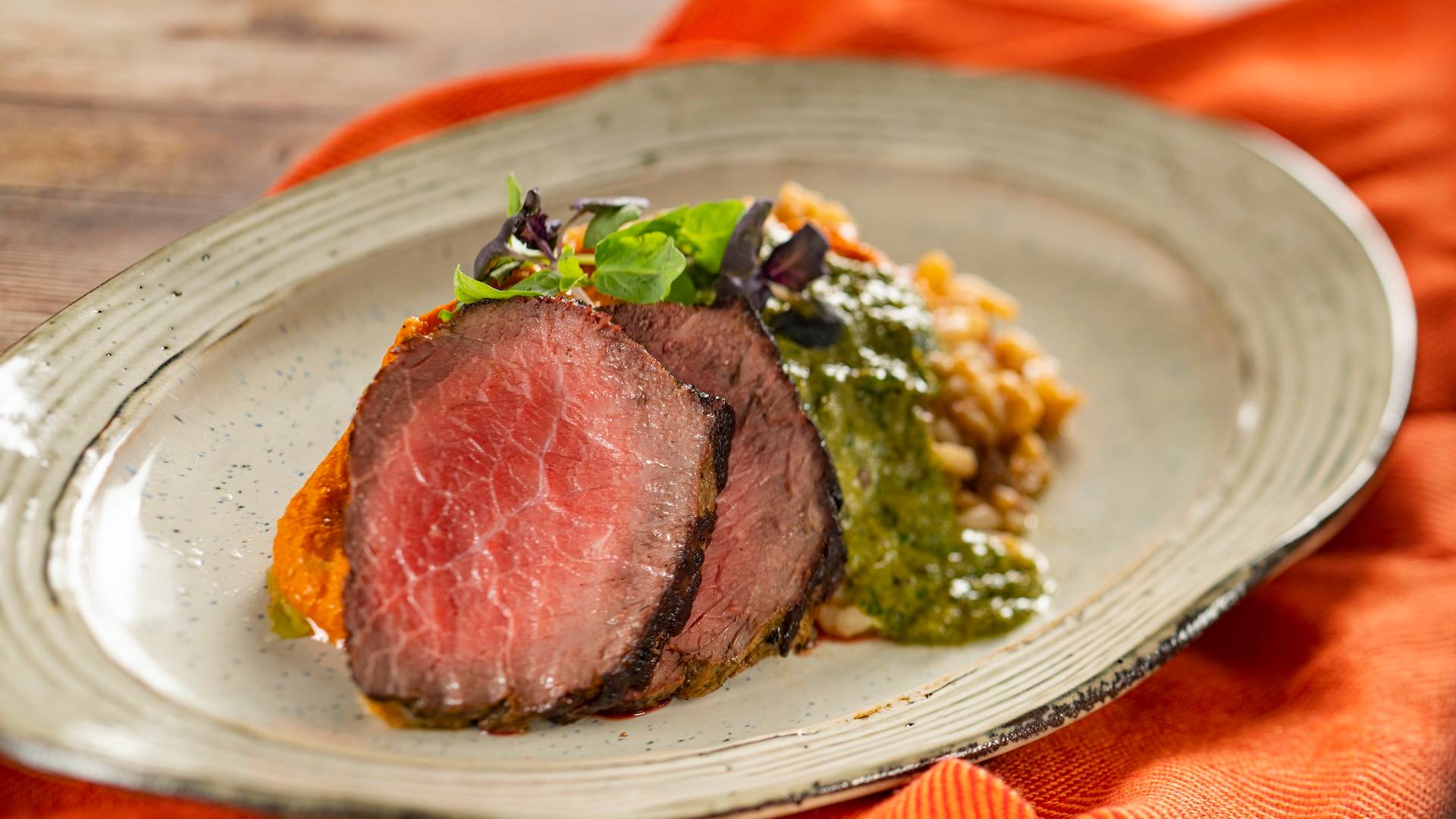 Grilled Beef Strip Loin with tomato risotto, tomato beurre blanc, and basil pesto