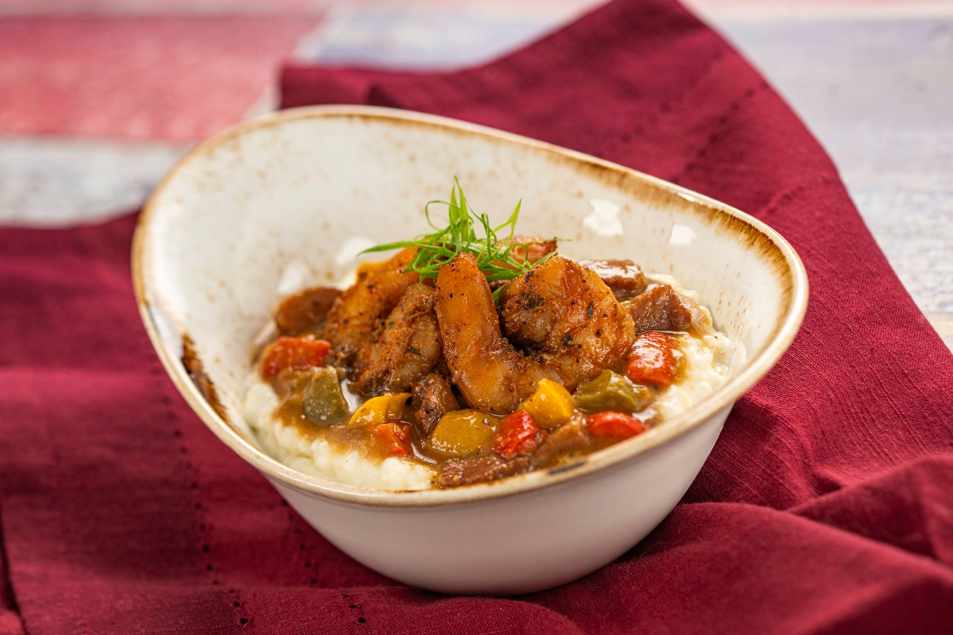 Shrimp and Grits: Blackened shrimp and cheddar cheese grits with tasso ham gravy, bell peppers, onions, and andouille sausage (New)