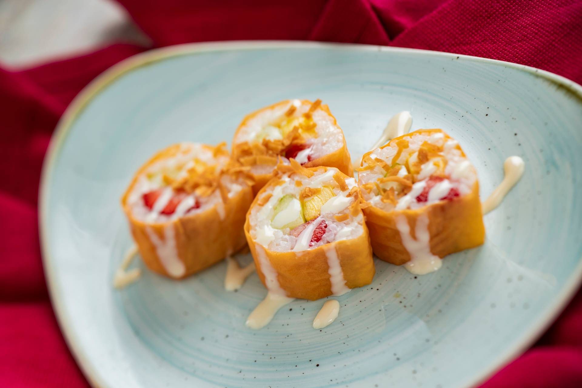 Frushi: Strawberry, pineapple, and honeydew wrapped in coconut rice and soy wrap paper served with coconut cream sauce and toasted coconut