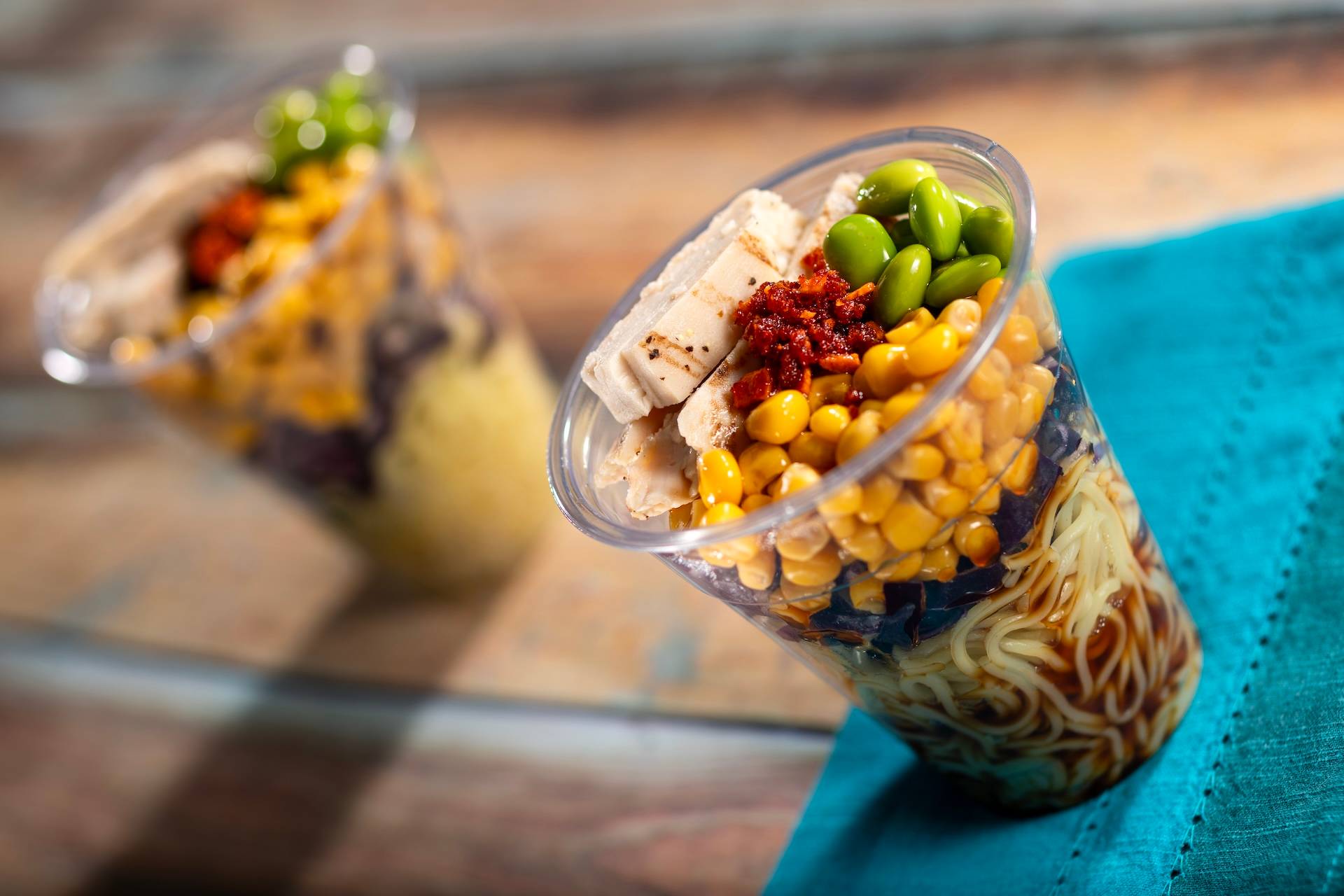 Ramen Cup: Cold ramen noodle salad in a cup with fresh vegetables and grilled chicken served with yuzu-soy vinaigrette and chili oil