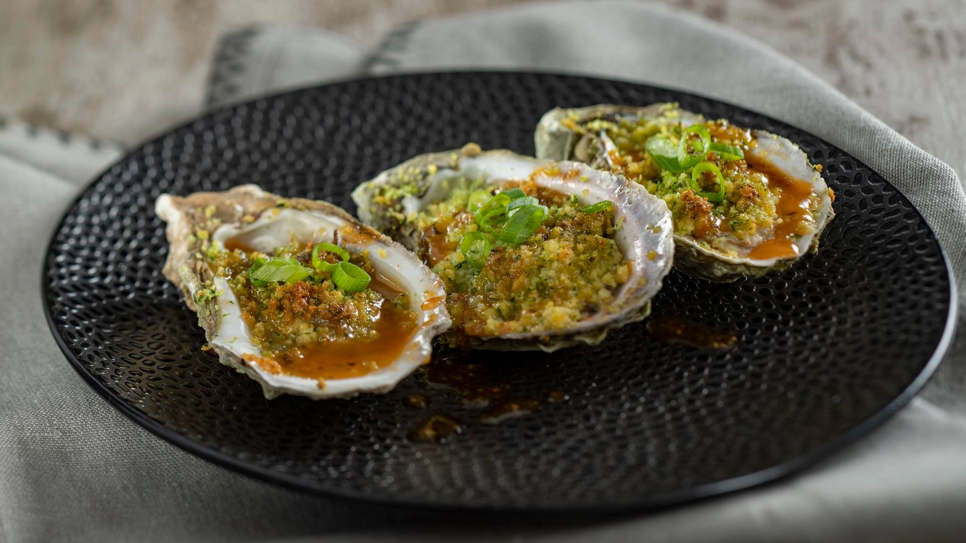 Grilled Gulf Oysters with andouille sausage butter and lemon