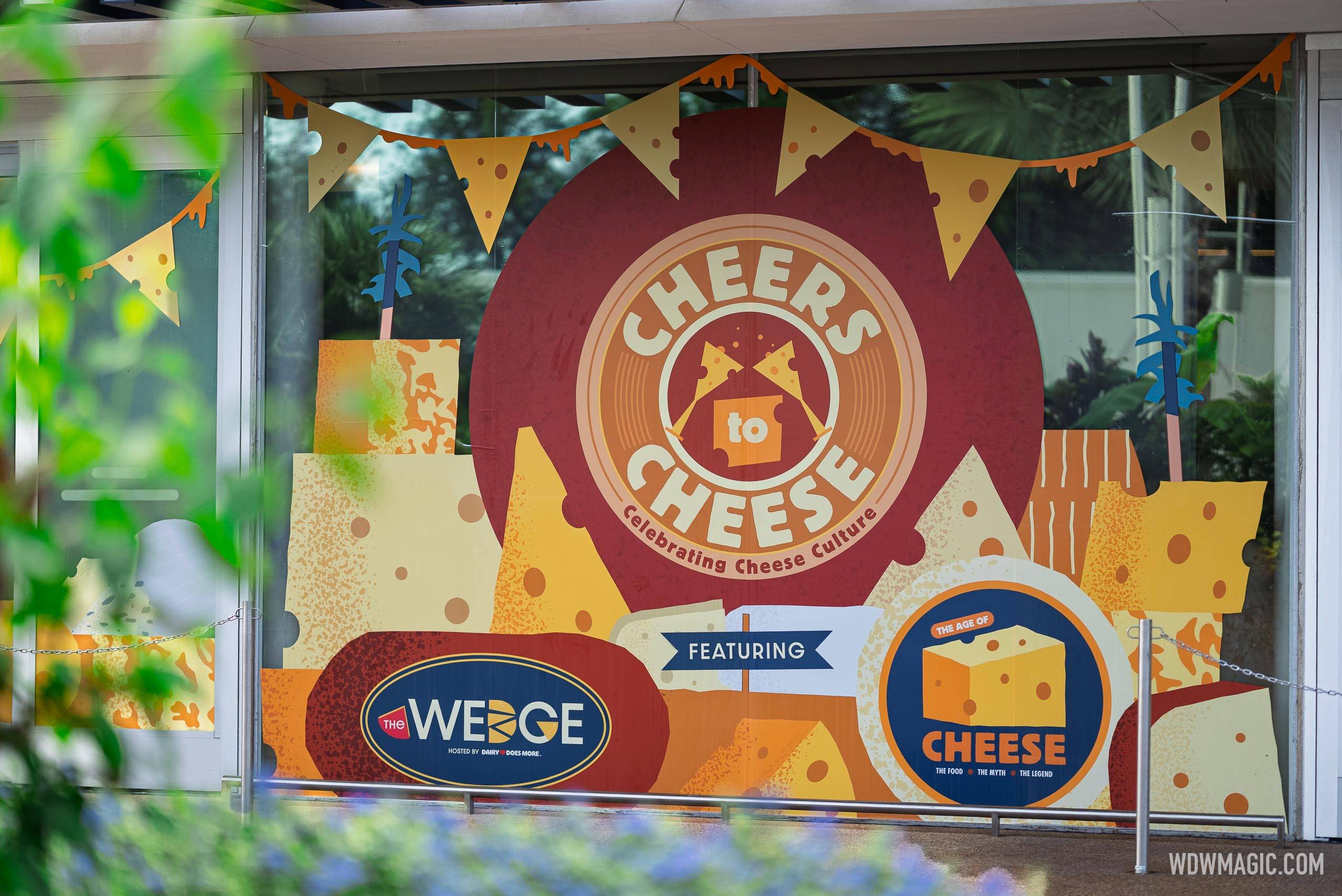 Signage for "Cheers to Cheese" and its two featured components, The Wedge and The Age of Cheese, displayed on the CommuniCore Hall windows