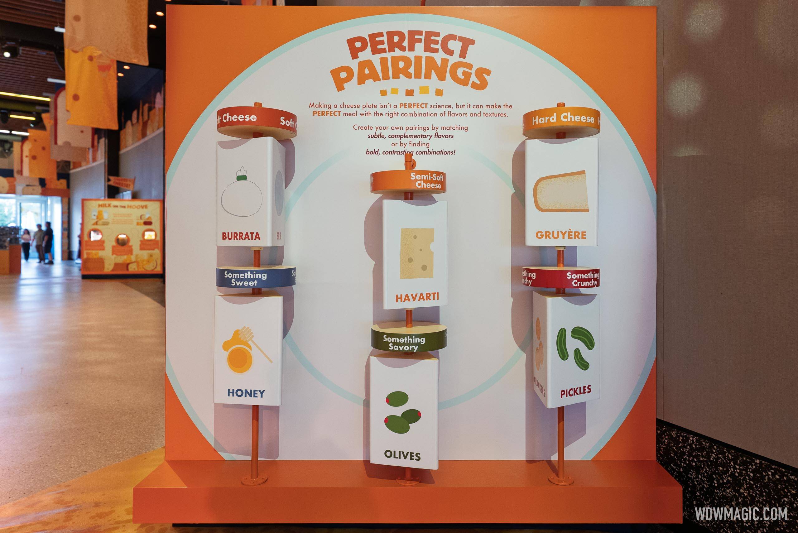 "Perfect Pairings" interactive display inside CommuniCore Hall guides guests through cheese board combinations using rotating columns featuring Burrata, Havarti, and Gruyère