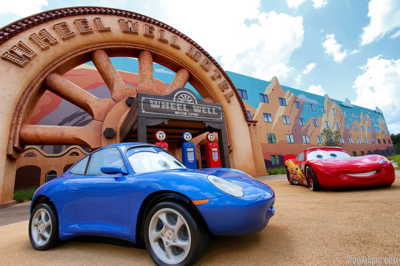 Lightning McQueen and Sally Carrera in front of the Wheel Well Motel building in Cars section at Disney's Art of Animation Resort