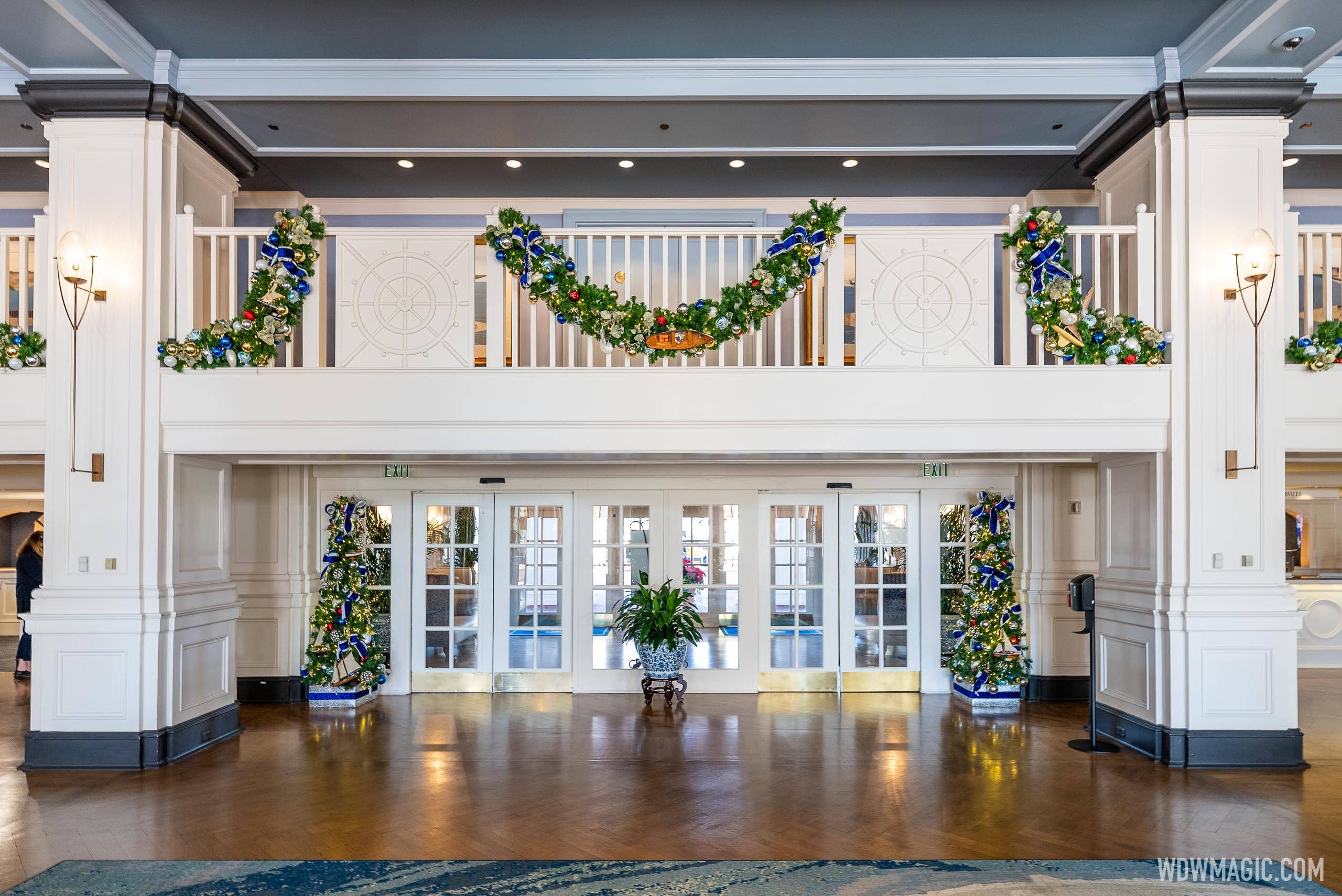 Small Christmas trees and garland surround the main entrance doors